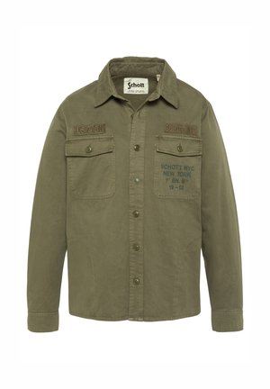 Veste boutonnée vert olive avec deux poches poitrine, étiquette Schott NYC et écussons de style militaire sur le devant.