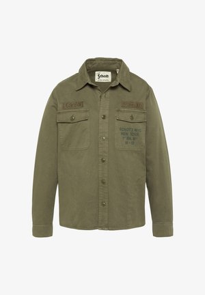 Olivengrøn knap-op jakke med to brystlommer, Schott NYC-mærke og militærinspirerede patches på forsiden.
