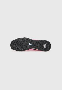 Sole di scarpa sportiva rosa con superficie in gomma nera testurizzata, caratterizzata da un prominente logo Nike in bianco e un accento di design arancione e nero di grande impatto.
