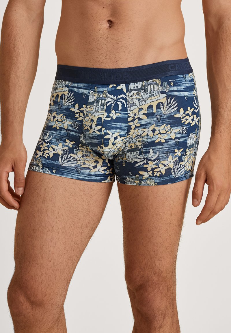 Blue shorts featuring a floral and landscape pattern in light beige. Made from soft fabric with an elastic waistband for comfort.