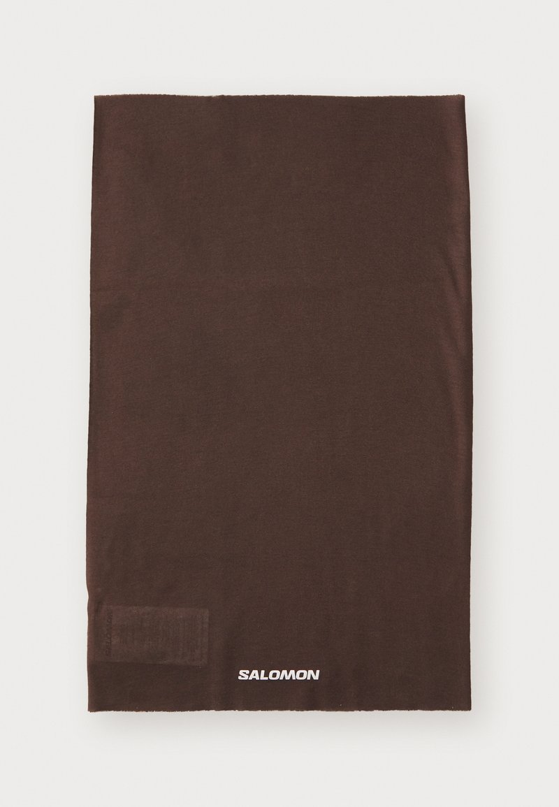Brun sømløs halsgaiter laget av myk stoff med en glatt tekstur; har en liten logo i hvitt nederst til venstre.