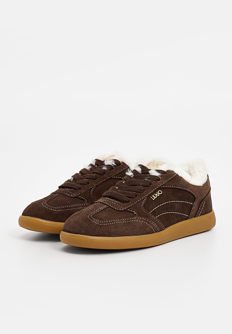 Sneaker in camoscio marrone con fodera in pelliccia bianca, dettagli in cucitura bianca e suola in gomma beige. Design classico con lacci e colletto imbottito.