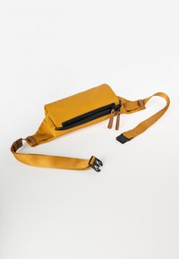 Geel nylon tas met een rechthoekige vorm, zwarte ritsluiting, bruine leren accenten en een verstelbare schouderband. Het oppervlak lijkt glad en mat.