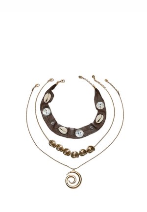 Trois colliers superposés : le haut avec un tissu foncé, des coquillages et des accents ronds ; le milieu avec des perles en spirale dorées ; le bas avec un pendentif en spirale doré.