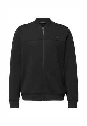 Chaqueta negra con cremallera hecha de tela suave. Presenta un cuello alto, puños acanalados y un diseño minimalista con un pequeño logo en el pecho.