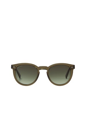 Lunettes de soleil rondes avec une monture translucide vert olive et des verres à dégradé sombre, ornées de petits points décoratifs en argent près des charnières.