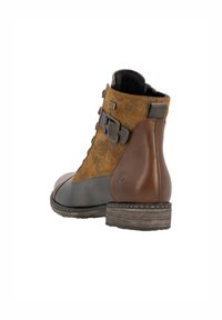 Bottine marron avec une tige en daim texturé, des accents en cuir, une boucle décorative et un petit talon empilé.