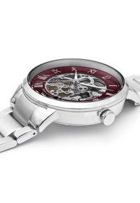 Reloj de acero inoxidable plateado con un dial burdeos, movimiento mecánico transparente, números romanos y una pulsera pulida.
