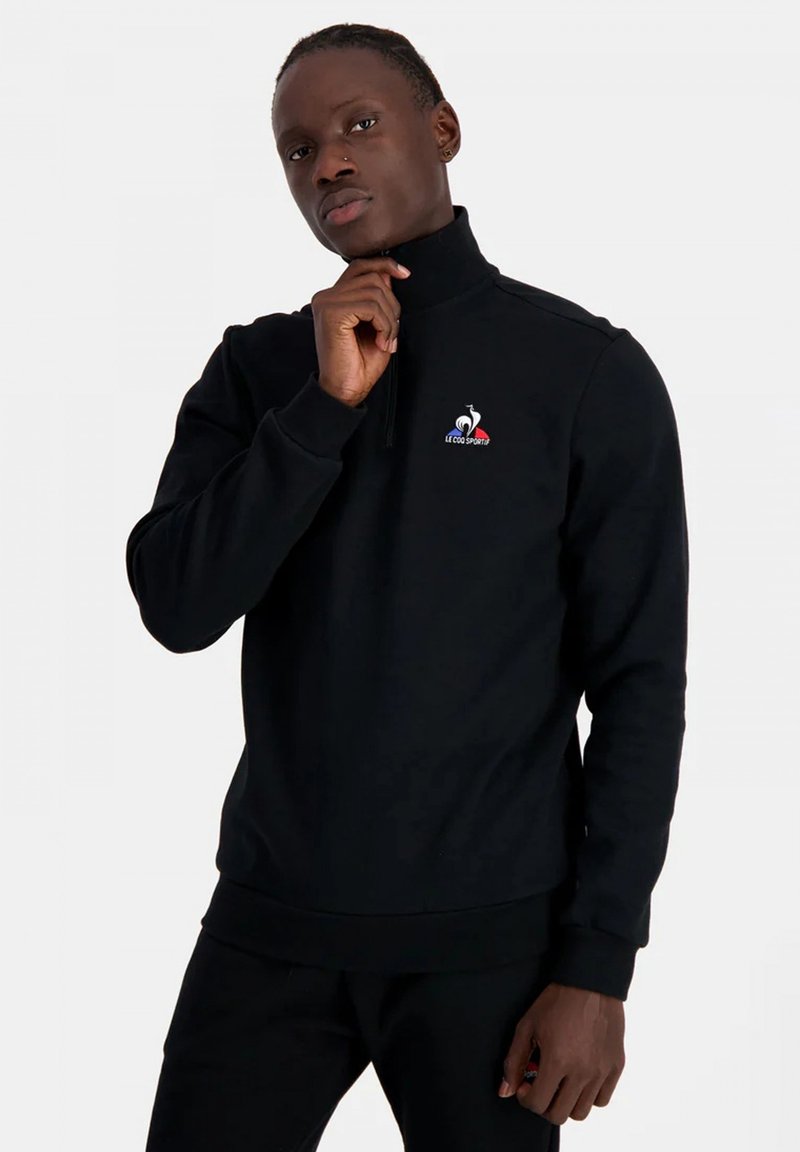 Zwarte zip-up sweatshirt met een opstaande kraag, voorzien van een logo op de linker borst, ribgebreide manchetten en een gestructureerde stofafwerking.