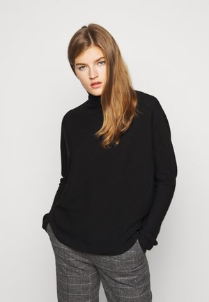 Schwarzer Rollkragenpullover mit lockerer Passform und langen Ärmeln, kombiniert mit grauen karierten Hochbundhosen. Glatte Textur, minimalistisches Design.