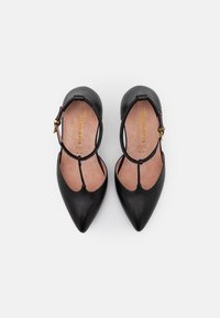 Czarne skórzane buty na szpilkach z ostrym noskiem i paskami na kostce, posiadające teksturowane wnętrze oraz mały złoty detal na pasku.