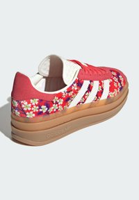 Buntes Sneaker mit Blumenmuster, Obermaterial aus pinkem und weißem Wildleder, strukturierte Zunge und transparente, geschichtete Gummisohle.