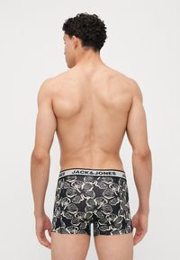 Fekete boxer alsónadrág krém virágmintával. Rugalmas derékpánton "JACK & JONES" felirat. Puha anyag és testhezálló kialakítás.