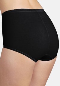 Culottes noires taille haute en matériau doux, présentant une texture lisse et une ceinture élastique, avec un minimum de détails de couture.