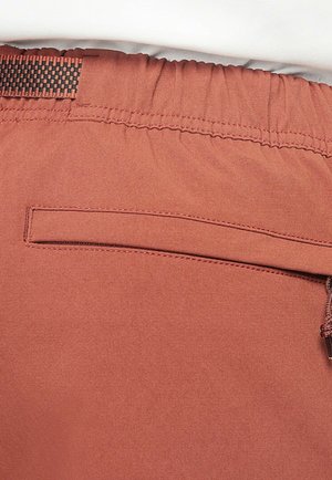 Rostfärgade shorts med elastisk midja, har en liten bakficka och slätt, lätt tyg.