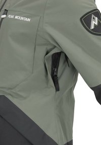 Veste verte avec des accents noirs, présentant une poche zippée et le logo "Peak Mountain". Fabriquée à partir d'un matériau lisse et résistant à l'eau.