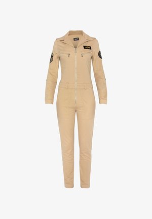 Salopette kaki avec un zip devant, des manches longues et un col. Elle comporte deux poches plaquées, un patch logo sur la poitrine et des accents au niveau des épaules.