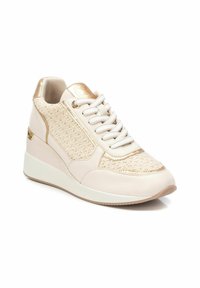 Zapatillas deportivas de cuña beige con acentos dorados, lados de tejido texturizado, cuero suave y punta redondeada. Cierre con cordones y un interior acolchado.