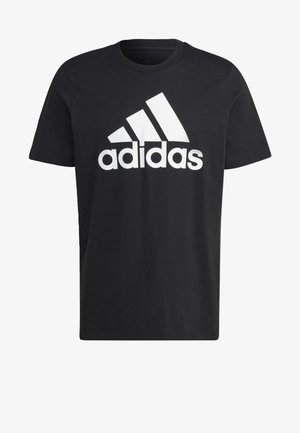T-shirt en coton noir avec un grand logo Adidas blanc et trois bandes diagonales sur la poitrine. Manches courtes et coupe standard.