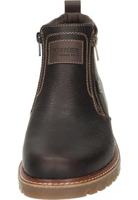 Bottine en cuir marron avec une texture lisse, fermeture éclair sur le côté, couture renforcée et semelle en caoutchouc avec un motif de crampons épais.