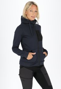 Navy zip-up hoodie with a black chest pocket, drawstrings, large front pockets, and fitted cuffs, made from soft, stretchy material.