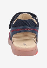 Marinblå sandal med öppen bak, ovandel i mesh och läder, röda sömmar, beige innersula och gummisula med orange detaljer.