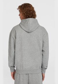 Grijze hoodie gemaakt van zachte stof, met een ontspannen pasvorm, ribgebreide manchetten en zoom, en met een zichtbare achternaad en capuchon.