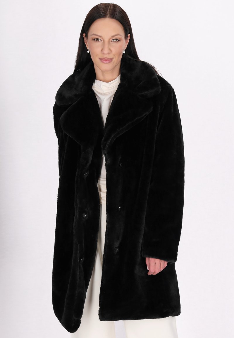 Sort faux fur frakke har en stor krave, knaplukninger og en blød, plysset tekstur. Designet er knælængde med en afslappet pasform.