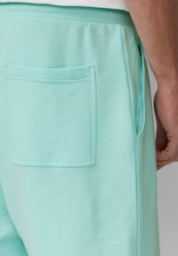 Mintgroene sweatpants van zachte stof, met een zijzak en een achterzak met een gestikte logodetail.