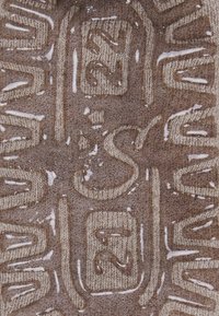 Brown textured fabric with embossed lettering. Includes subtle sheen and water droplets. Features woven patterns in light beige.