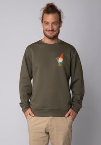 Olivenfarbener Sweatshirt aus Baumwolle mit einem bunten Gartenzwerg-Design auf der Brust. Runder Ausschnitt und gerippte Bündchen.