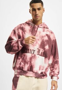 Felpa con cappuccio a tie-dye rosa con accenti scuri, caratterizzata da una tasca frontale e la frase "Thug Life" in nero bold. Realizzata in tessuto morbido.