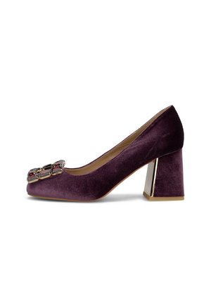 Zapato de tacón ancho para mujer en terciopelo púrpura con puntera cuadrada y gran adorno rectangular con joyas en la parte delantera.