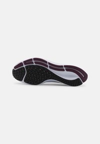 Semelle de chaussure avec un tapis en caoutchouc noir et bordeaux pour l'adhérence, une semelle intermédiaire blanche et des rainures flexibles pour la course ou les activités sportives.