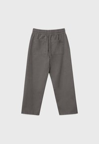 Harmaat joustavat vyötäröhousut, joissa on kaksi suurta takataskua, suora lahkeensuukutsu, esitelty vaalealla yksinkertaisella taustalla.