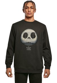 Black sweatshirt featuring a large graphic of a skull with two figures inside the eye sockets, labeled "The Nightmare Before Christmas."