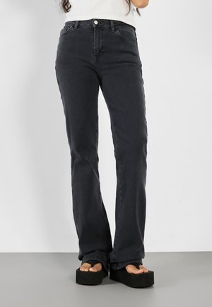 Sorte denim jeans med lige ben, fem-lomme design og subtile syninger; båret med platforme sandaler.