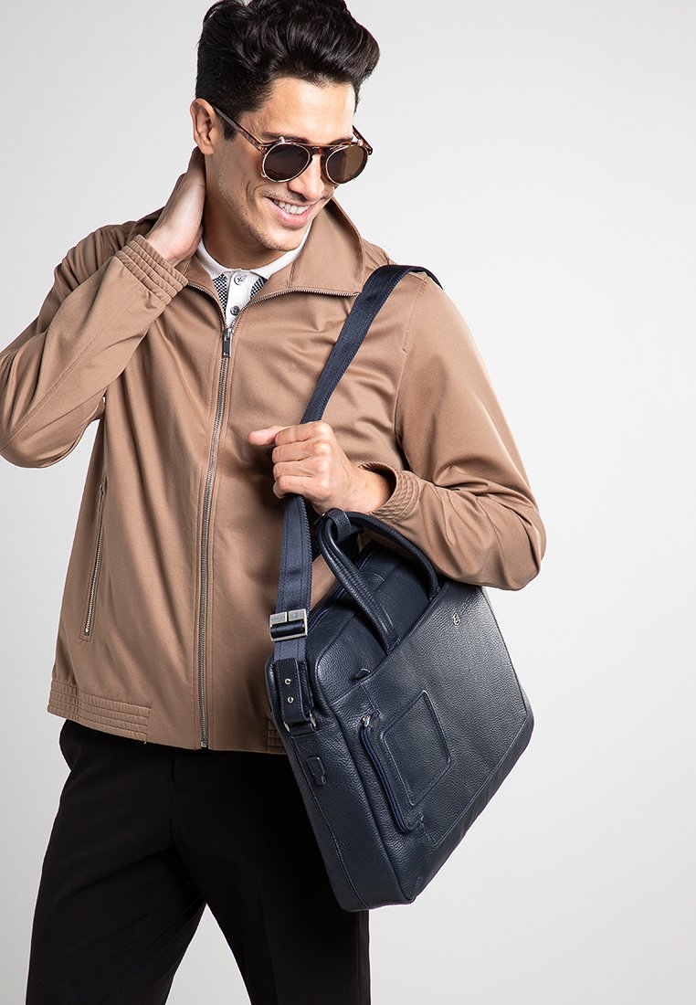 Borsa messenger in pelle blu navy con doppi manici superiori e tracolla regolabile, dotata di tasca anteriore e finitura testurizzata.
