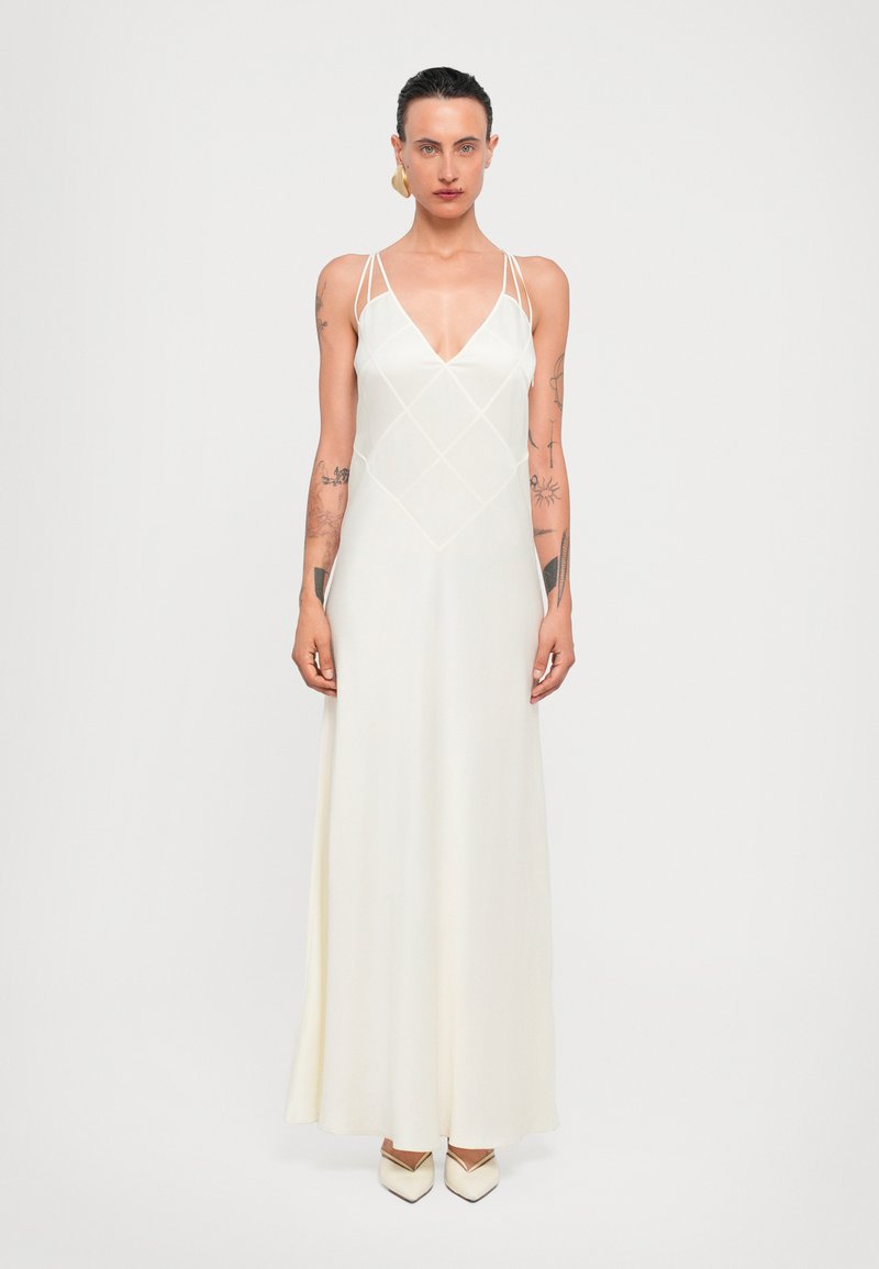 Robe maxi en tissu blanc doux avec un décolleté en V, des bretelles spaghetti, un motif en losange sur le corsage et une silhouette fluide.