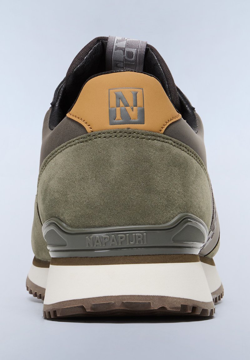 Zapatilla verde y beige con materiales de ante y cuero, que presenta un dorso texturizado, suela de goma y un detallado logo prominente.
