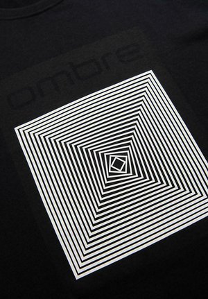 Koncentriske hvide firkanter med vekslende tykkelse danner en optisk illusion på en sort stofbaggrund.