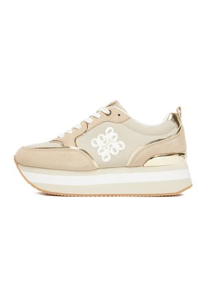 Beżowo-białe sneakersy na platformie z wiązaniem z przodu, siateczkową i zamszową cholewką, białym bocznym logo i metalicznym złotym detalem na pięcie.