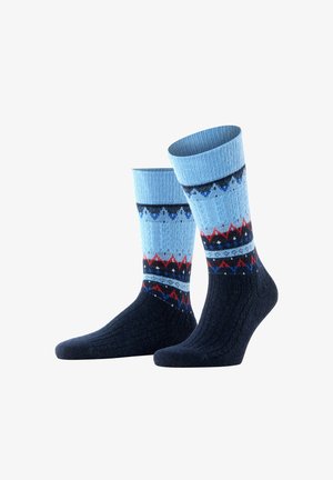 Gestrickte Socken mit einem hellblauen und marineblauen Design, roten und blauen Zickzackmustern, gerippten Bündchen und einem strukturierten, warmen Stoff.
