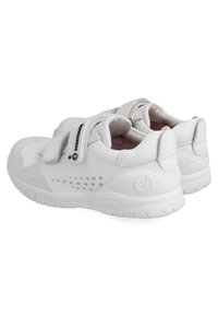 Zapatos deportivos blancos con un exterior de cuero suave, correas de gancho y bucle, detalles laterales perforados y una suela de goma texturizada.
