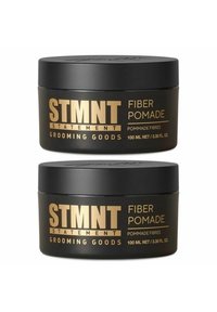 Black containers of STMTNT Fiber Pomade with gold text. Each jar holds 100 ml. Smooth surface with a rounded lid and minimalistic design.