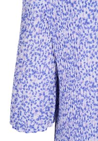 Jupe plissée violet clair avec un petit motif floral bleu et une fente verticale centrale.