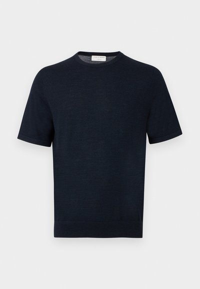 Μπλε ναυτικό πουκάμισο πλεκτό με κοντά μανίκια, στρογγυλή λαιμόκοψη, απλή υφή και ετικέτα στο πίσω μέρος του λαιμού.