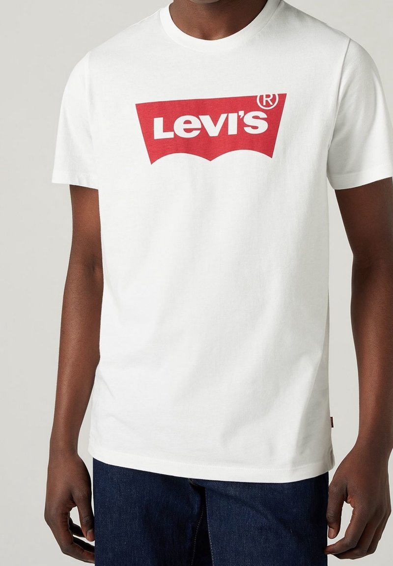 T-shirt en coton blanc avec un grand logo Levi's rouge en design courbé. Les manches courtes et l'encolure ronde complètent le look.