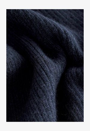 Tumši jūraszilas ribota auduma ar mīkstu tekstūru, attēlo viļņveida rakstu un smalku pūkainību, kas norāda uz siltumu un biezumu.