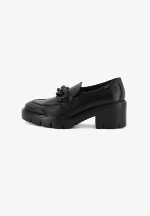 Mocassin en cuir noir avec un talon chunky, une semelle épaisse striée et un détail décoratif en chaîne sur le dessus, présenté sur fond blanc.